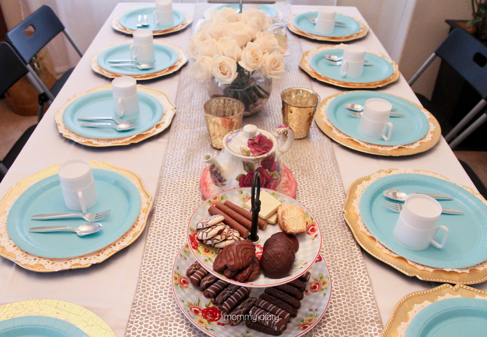 Rose teapot: hand-me-down from my mother. Two-tier tray & table runner: Homegoods. Gold charger & votive candle holders: Kirkland's. Plastic cup, flatware & plate: Party City.