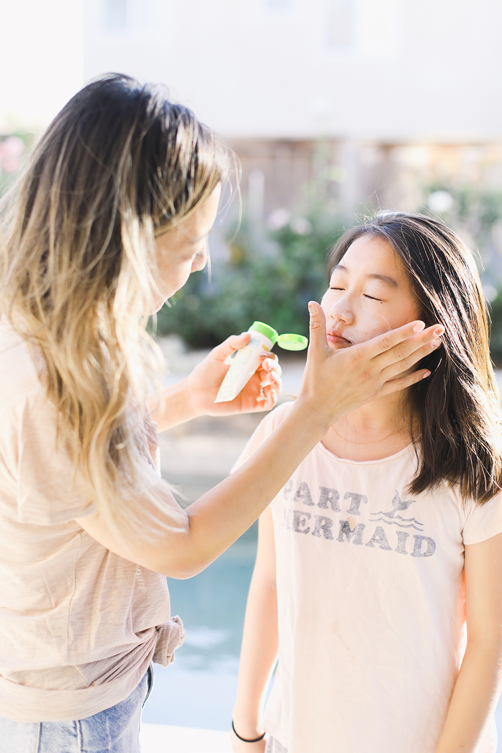 mom putting sunblock on daughter's face